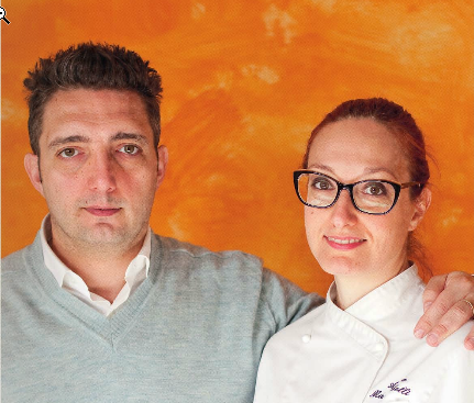 Chef e sommelier: ritratto di coppia di esperti culinari su sfondo arancione.