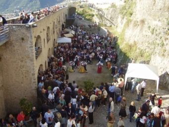 Festa al Castello Malaspina: folla, danze tradizionali e bancarelle. Evento culturale e turistico.