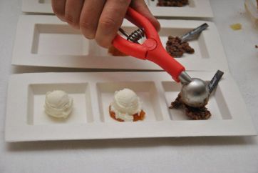 Gelato artigianale: preparazione di degustazione con porzionatore e coppette. Dessert gourmet.