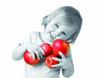 Bambina sorridente con mele rosse. Frutta fresca, alimentazione sana per bambini.