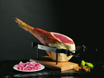 Prosciutto di San Daniele DOP su tagliere. Salume tipico italiano, affettato e pronto da gustare.