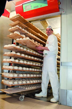 Panettiere con carrello di pane fresco. Alberto Boni, panificio artigianale. Prodotti da forno, pane fatto in casa.