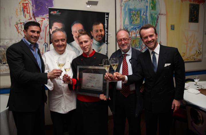 Chef premiato con squadra e calici di vino. Ristorante stellato, cucina gourmet. Festeggiamenti e brindisi.