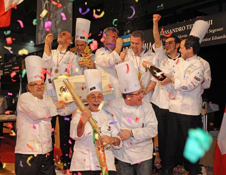 Team di chef festeggiano vittoria a SIGEP, con coriandoli e champagne. Concorsi di pasticceria e gelateria.