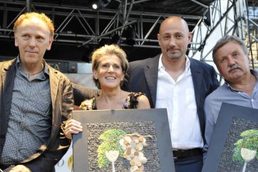 Premiazione Aria di Festa: gruppo di persone con mosaici uva e calice. Evento enogastronomico.
