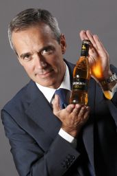 Uomo in giacca mostra Strongbow Gold. Sidro di mele frizzante in bottiglia di vetro.