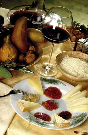 Assortimento di formaggi pecorino con confetture e vino rosso. Degustazione di prodotti tipici italiani.