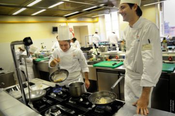 Chef in cucina professionale. Corsi di cucina e formazione professionale. Allievo chef sorridente.