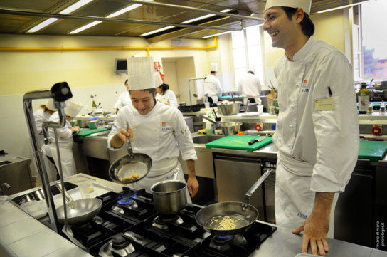 Chef in cucina professionale. Corsi di cucina e formazione professionale. Allievo chef sorridente.