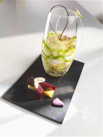 Dolce in vetro con decorazioni e assaggi su ardesia. Dessert gourmet, cucina creativa.