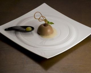 Mousse al cioccolato e crème brûlée all'arancia con arancia sferificata. Dessert gourmet.