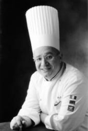 Ritratto in bianco e nero di chef sorridente con cappello da cuoco. Cucina italiana.