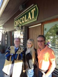 Persone davanti a Chocolat, negozio di cioccolato artigianale. Sorrisi, moda casual.