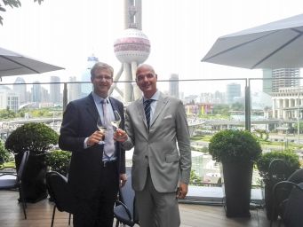 Gianluca Bisol e Edouard Duval brindano con Prosecco Bisol a Shanghai. Celebrazione e panorama urbano.