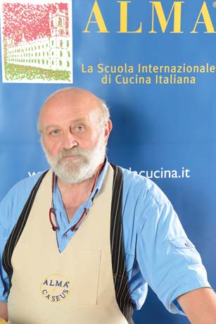 Chef Brancaleoni all'ALMA, scuola di cucina italiana. Divisa da chef, barba bianca. Cucina professionale.