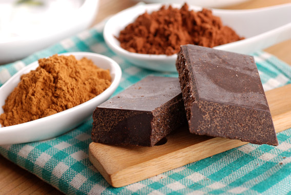 Cioccolato di Modica artigianale su tagliere con cacao in polvere. Gusto intenso, prodotto tipico siciliano.