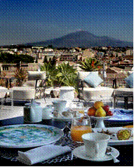 Colazione con vista sull'Etna, Sicilia. Tavolo imbandito con frutta fresca e bevande. Vacanza in Italia.