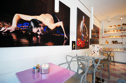 Interno di locale con foto d'arte, tavoli e sedie di design. Arredamento moderno.