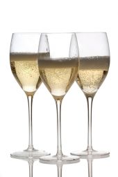 Tre calici di spumante. Brindisi con vino frizzante, bollicine dorate. Celebrazione, festa.