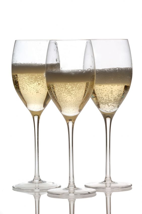 Tre calici di spumante. Brindisi con vino frizzante, bollicine dorate. Celebrazione, festa.