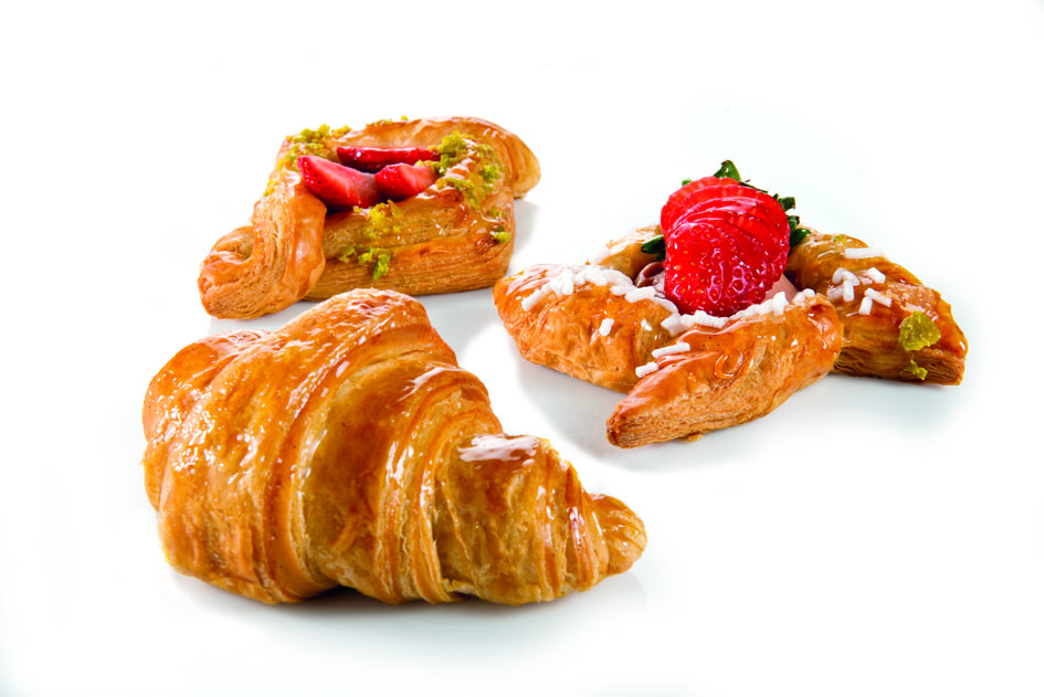 Croissant e dolci assortiti. Pasticceria italiana con fragole e pistacchio. Colazione golosa.
