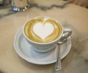 Cappuccino artistico con cuore. Caffè italiano, colazione romantica.