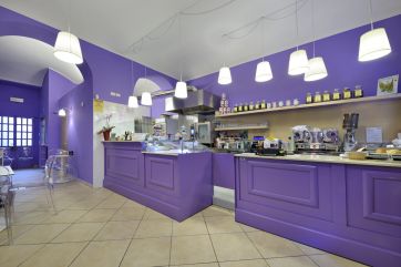 Interno di caffetteria viola. Arredamento moderno, illuminazione con lampade a sospensione. Design accogliente.