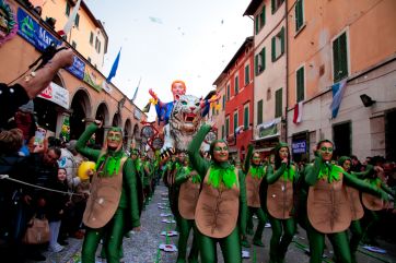 Carnevale: sfilata con gruppo mascherato da tartarughe e carro allegorico. Festa tradizionale italiana.