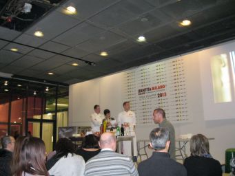 Congresso Identità Milano 2013: chef in scena. Pubblico attento durante la presentazione culinaria. Evento gastronomico.