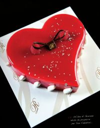 Torta a forma di cuore rossa. Dessert romantico con lamponi e decorazioni.