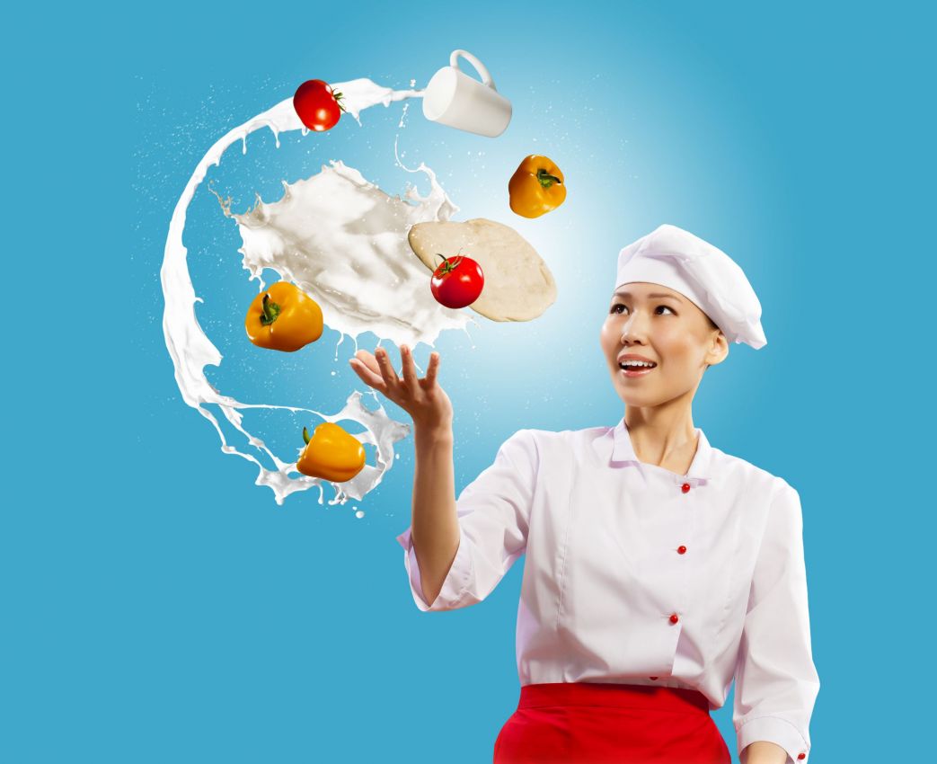 Chef sorridente con ingredienti volanti: pomodori, peperoni, latte. Cucina creativa, alimentazione sana.