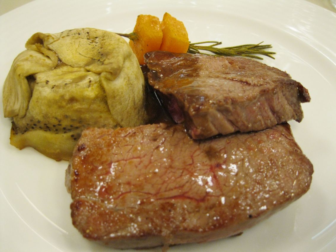 Filetto di manzo al sangue con contorno di verdure. Piatto gourmet, cucina raffinata.