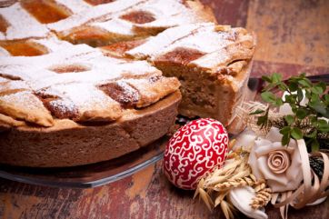 Pastiera napoletana con zucchero a velo, uovo di Pasqua decorato. Dolce tradizionale pasquale.