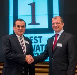 Premio innovazione: due uomini in giacca si stringono la mano. Leader aziendali, evento di premiazione.