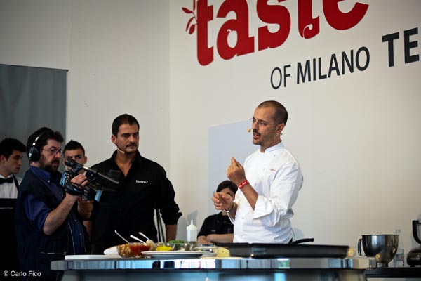 Chef a Taste of Milano spiega ricetta. Cameraman riprende showcooking. Cucina, food eventi.