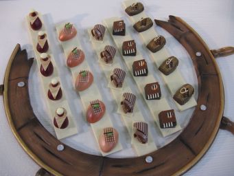 Assortimento di cioccolatini artigianali su ruota decorativa. Praline gourmet, dolci creativi, cioccolato di lusso.