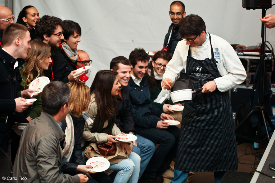 Chef serve cibo a gruppo. Degustazione culinaria, evento gastronomico. Persone sorridenti con piatti.