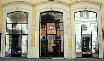 Vetrina Illy Shop a Roma. Negozio di caffè italiano con insegna Illy. Design elegante e moderno.