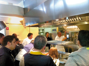 Chef in cucina professionale con gruppo di persone. Ristorante, formazione culinaria.