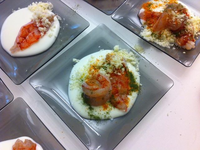 Gamberi su crema bianca con formaggio grattugiato. Piatti gourmet, cucina creativa, antipasto di pesce.