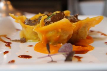 Cappelletti ripieni di coniglio con tartufo, pasta fresca all'uovo. Cucina italiana.