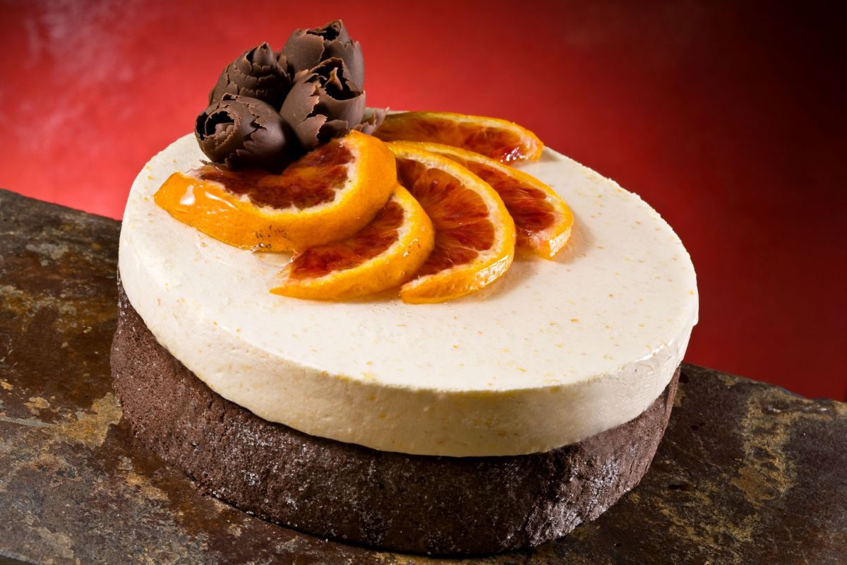 Torta cioccolato arancia: dessert goloso con decorazioni di cioccolato e fette d'arancia.