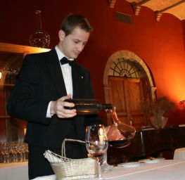 Sommelier italiano versa vino da bottiglia in decanter. Degustazione vino rosso.