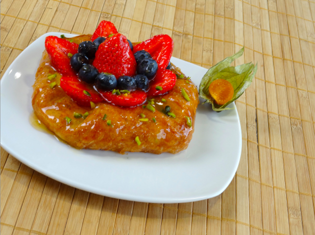 Dolce con fragole e mirtilli su piatto bianco. Pasticceria fresca con frutta. Dessert goloso.