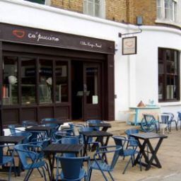 Caffetteria Ca' puccino con tavolini esterni. Design accogliente per colazione e pausa caffè.