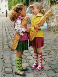 Due bambine con baguette francesi. Moda bambini, abbigliamento colorato, calze a rombi e scarpe pois. Stile francese.