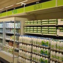 Scaffali Auchan bio con latte, uova e prodotti freschi. Supermercato con alimenti biologici.