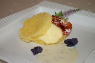 Dolce sandwich con crema vaniglia. Piatto gourmet con guarnizioni viola e fiori. Cucina raffinata.