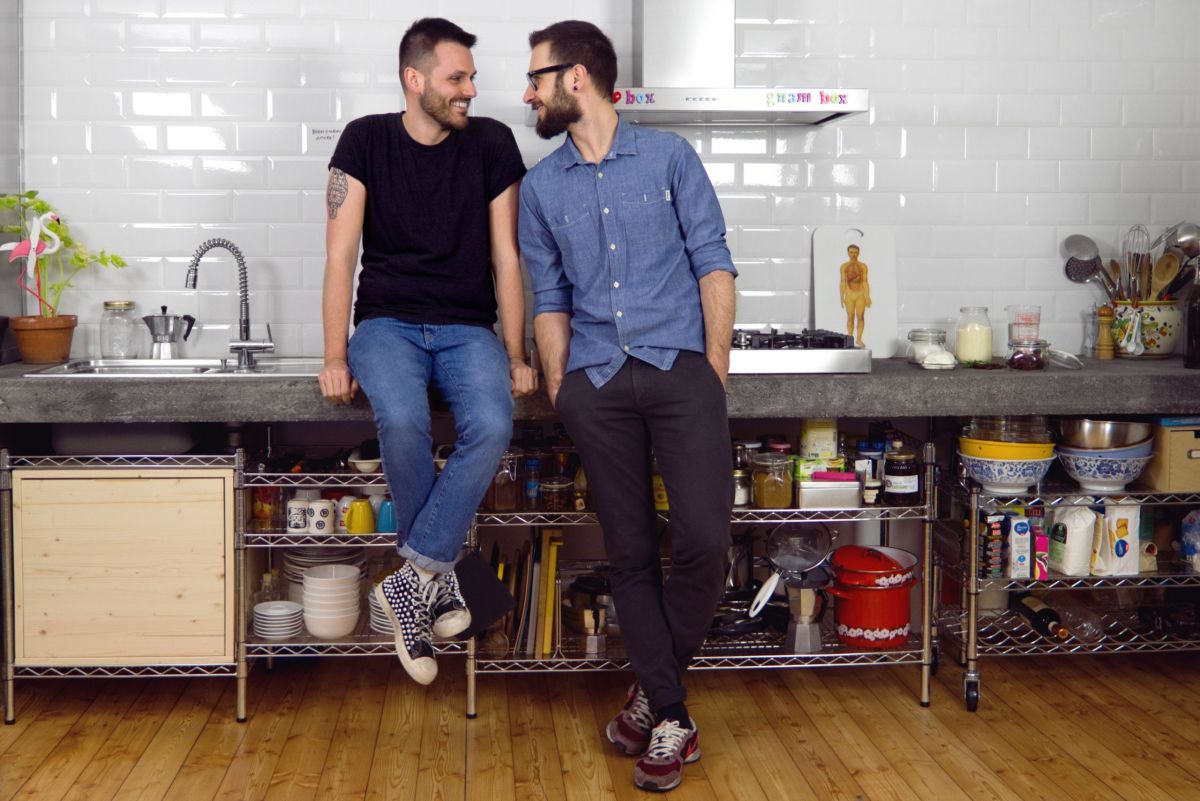 Due uomini in cucina. Interior design moderno, scaffali aperti, stile di vita.