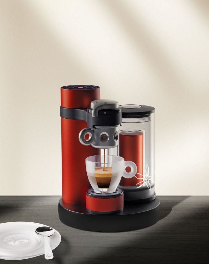 Macchina da caffè Illy rossa con tazzina di espresso. Design moderno, bevanda calda, pausa caffè.